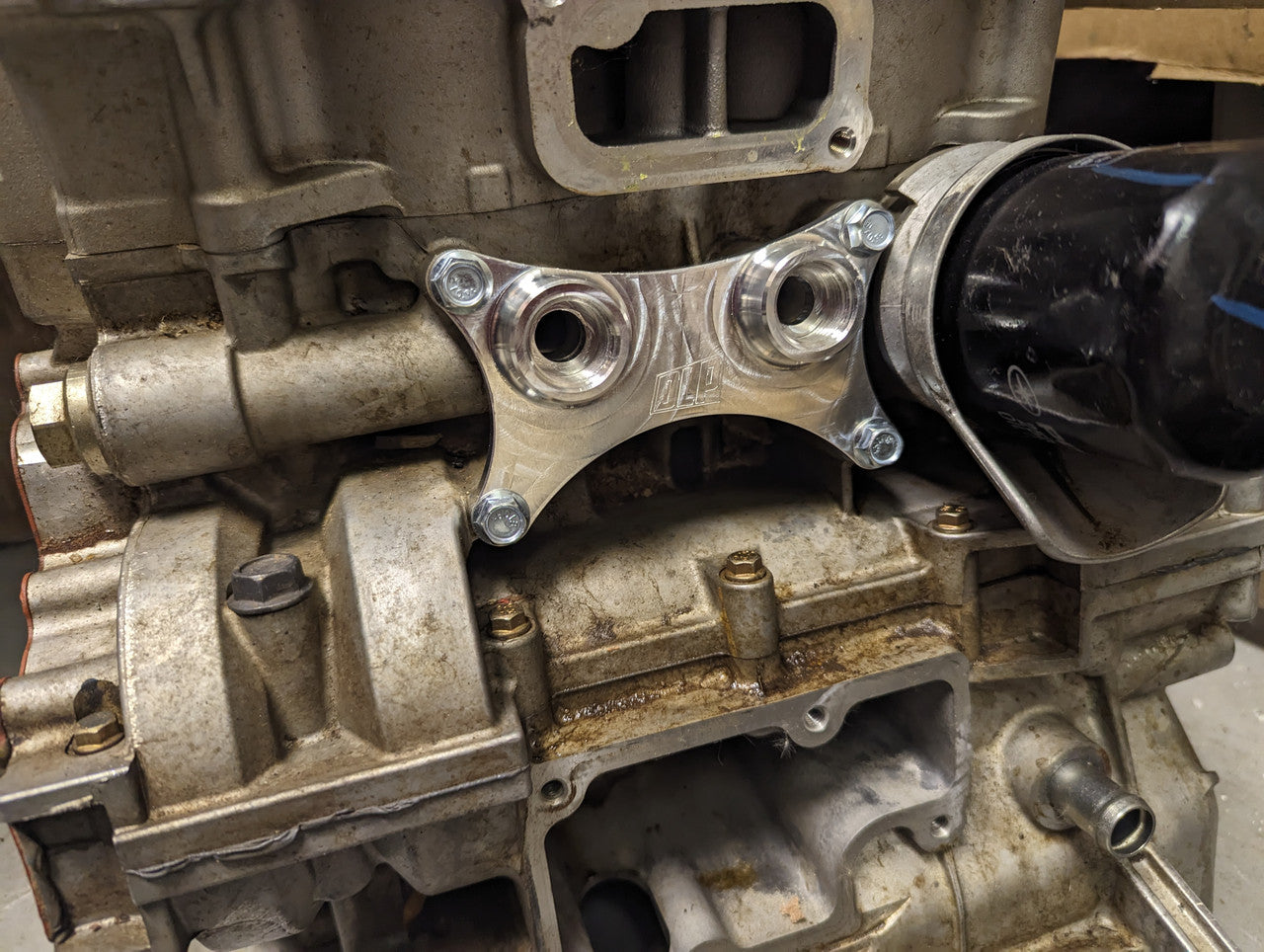 Oil cooler adapter installed on Polaris RZR engine showing external oil line routing capability.